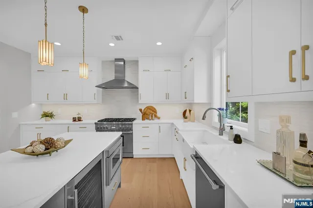 a kitchen with kitchen island white cabinets and appliances