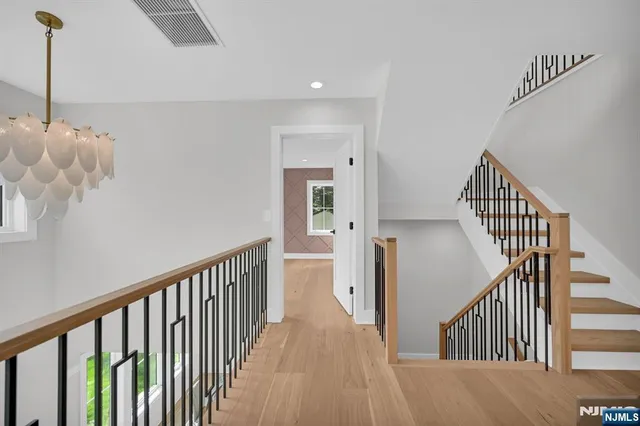 a view of a hallway with wooden floor and stairs