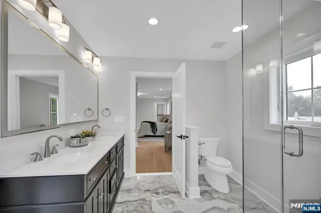 a spacious bathroom with a granite countertop sink mirror and toilet