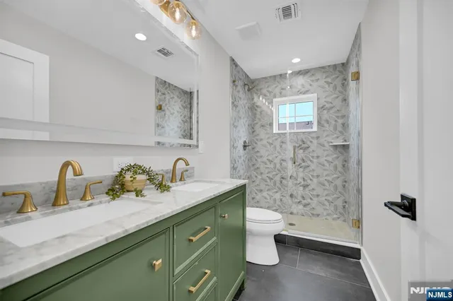 a bathroom with a double vanity sink toilet and shower
