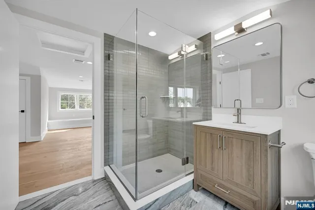 a bathroom with a shower sink and mirror