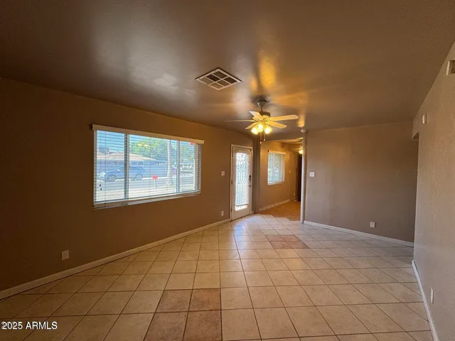 a view of an empty room with a chandelier fan