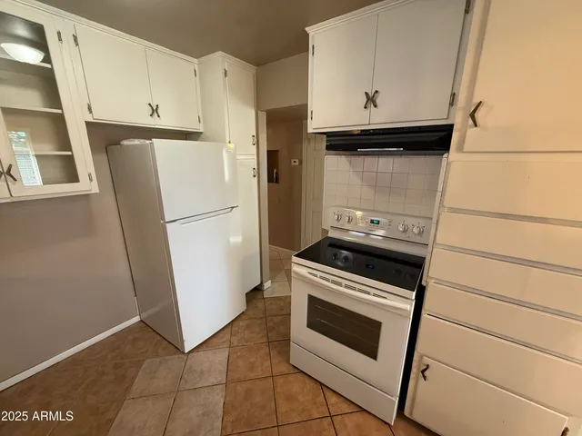 a kitchen with a stove top oven and refrigerator