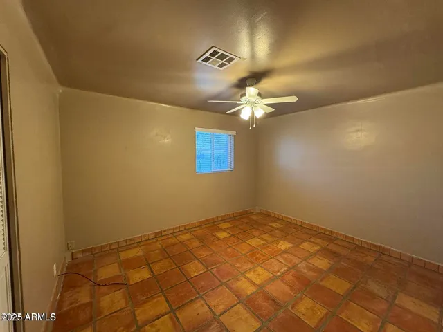 a view of a room with a chandelier fan and wooden floor