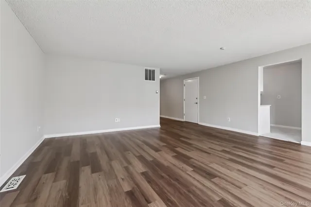 a view of an empty room and wooden floor