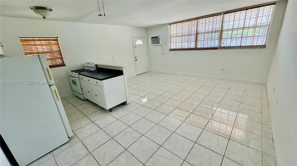 a kitchen with stainless steel appliances granite countertop a refrigerator a sink a stove and white cabinets