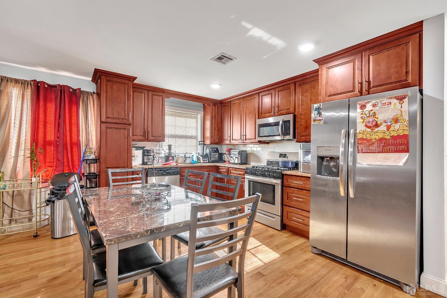 B Wright Place New Brunswick, NJ 08901 - Photo 11 of 34 a kitchen with stainless steel appliances granite countertop a refrigerator a stove top oven a sink dishwasher and wooden cabinets with wooden floor