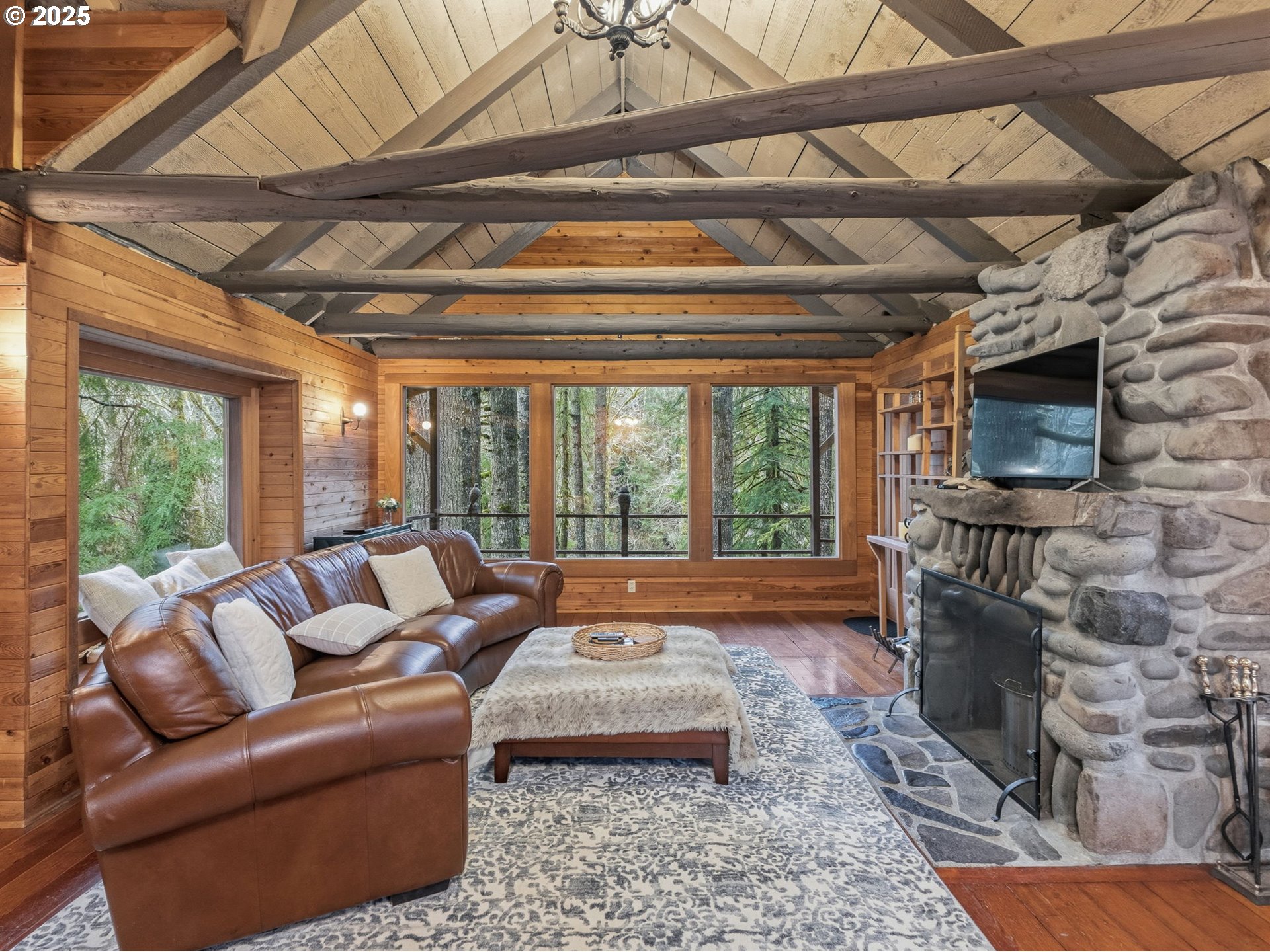 78506 Highway 53 Nehalem, OR 97131 - Photo 24 of 48 a living room with furniture a flat screen tv and a floor to ceiling window