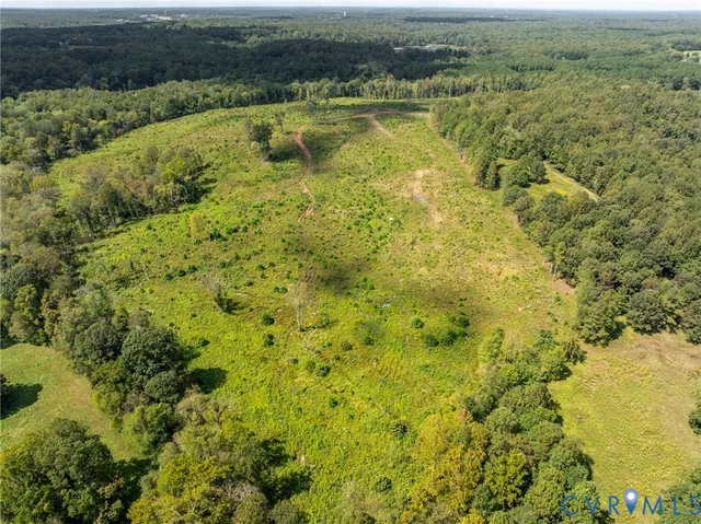 an aerial view of residential houses with outdoor space and trees