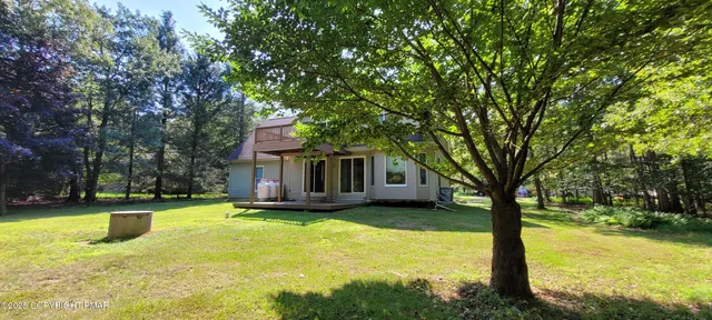 an aerial view of a house with a yard and large trees
