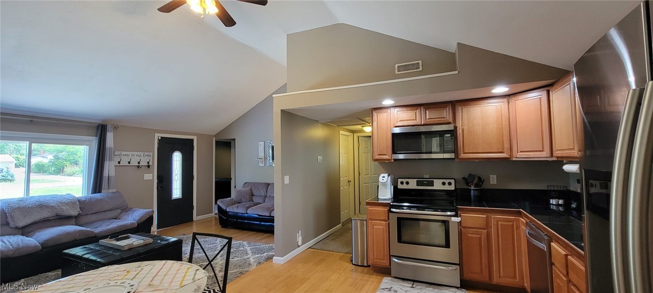 5770 Jaycox Road North Ridgeville, OH 44039 - Photo 12 of 31 Kitchen with light hardwood flooring, lofted ceiling, brown cabinets, ceiling fan, and appliances with stainless steel finishes