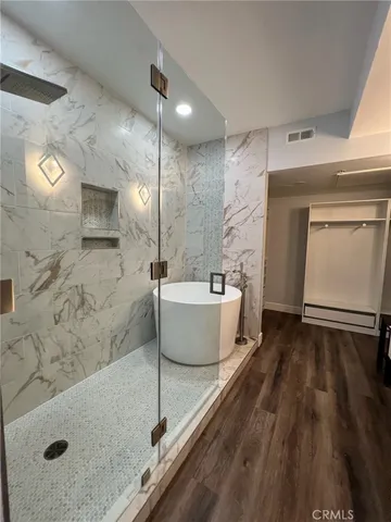 a bathroom with a sink a toilet a mirror and a shower