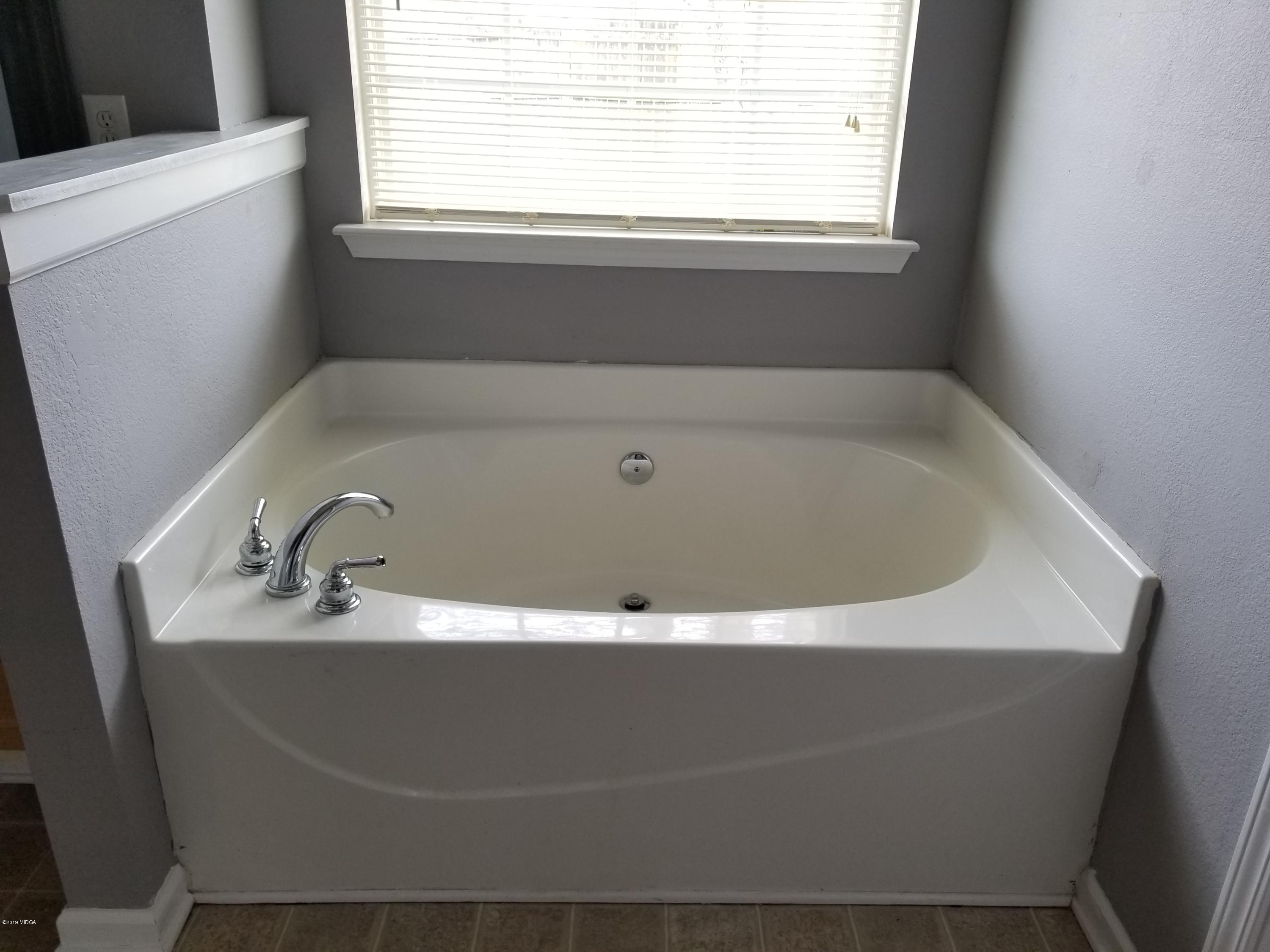 425 Bob White Road Macon, GA 31216 - Photo 20 of 20 a bath tub sitting in a bathroom next to a window