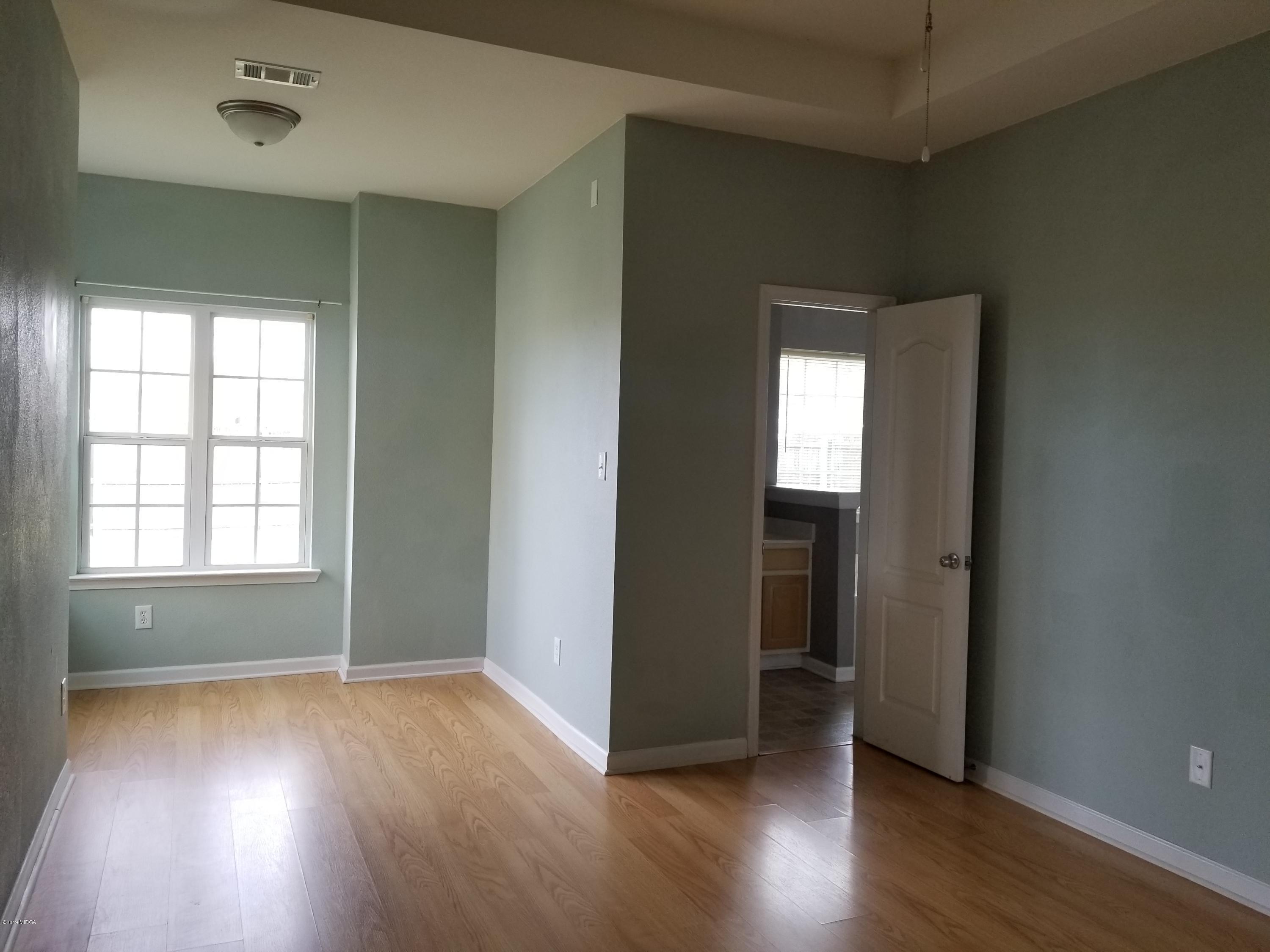 425 Bob White Road Macon, GA 31216 - Photo 7 of 20 an empty room with wooden floor and windows