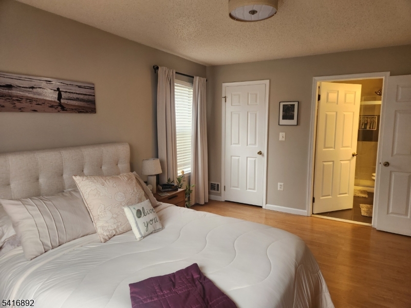 330 Penns Way Bernards, NJ 07920 - Photo 11 of 13 a bedroom with a large bed and a chandelier