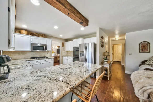 a large kitchen with kitchen island granite countertop a large counter top appliances and cabinets