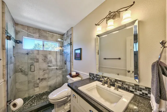 a bathroom with a sink toilet double vanity and shower
