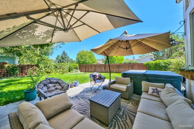 a patio view with a table and chairs under an umbrella