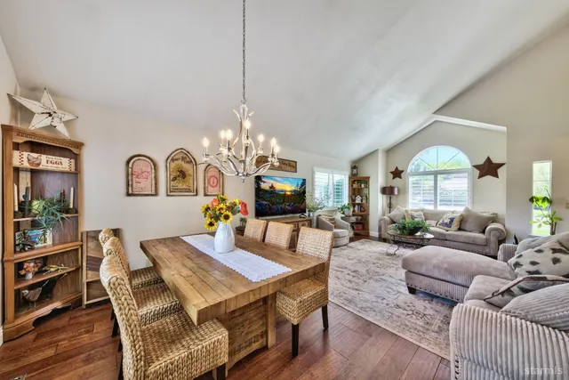 a living room with furniture a chandelier and a flat screen tv