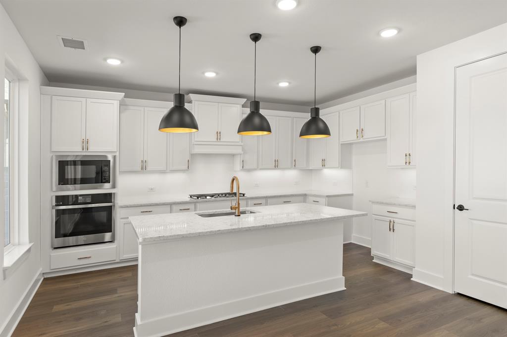 4100 Explorer Way McKinney, TX 75071 - Photo 12 of 27 a kitchen with kitchen island a sink stainless steel appliances and cabinets