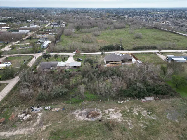 an aerial view of residential houses with outdoor space and trees