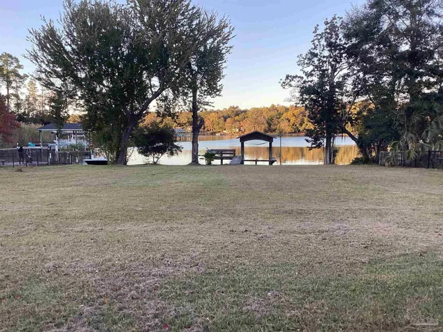 a view of a house with a yard and large tree