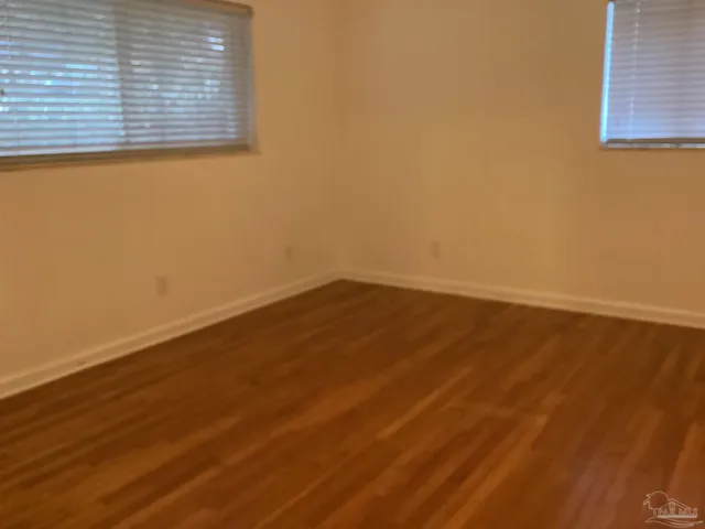 a view of a small space with wooden floor and a window