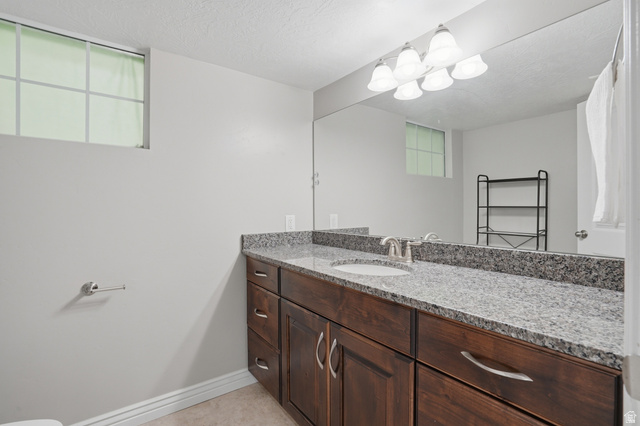 1997 East 600 South Springville, UT 84663 - Photo 47 of 54 Dark wood-finish vanity with a light granite-patterned countertop, undermount sink, and brushed nickel faucet