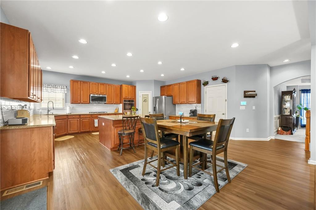 1203 Big Tree Pointe Villa Rica, GA 30180 - Photo 12 of 42 a view of a dining room with furniture wooden floor and a kitchen