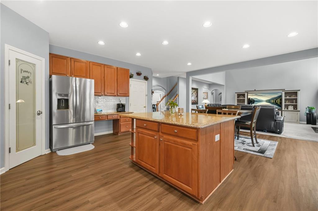 1203 Big Tree Pointe Villa Rica, GA 30180 - Photo 15 of 42 a kitchen with stainless steel appliances granite countertop a refrigerator oven a sink dishwasher and a dining table with wooden floor