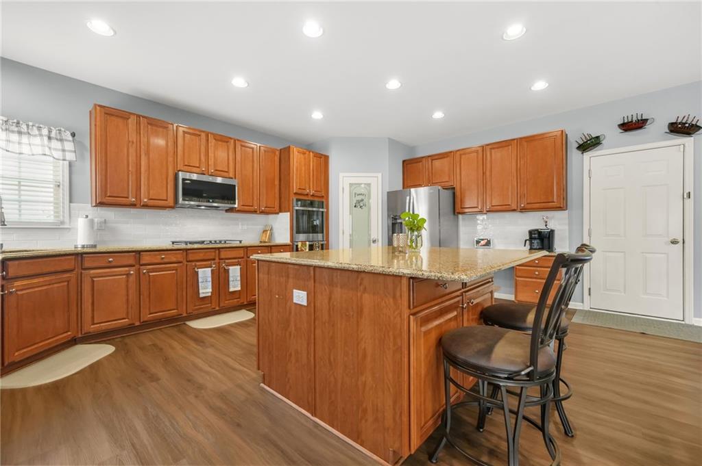 1203 Big Tree Pointe Villa Rica, GA 30180 - Photo 16 of 42 a kitchen with stainless steel appliances granite countertop wooden cabinets a sink a stove a dining table and chairs