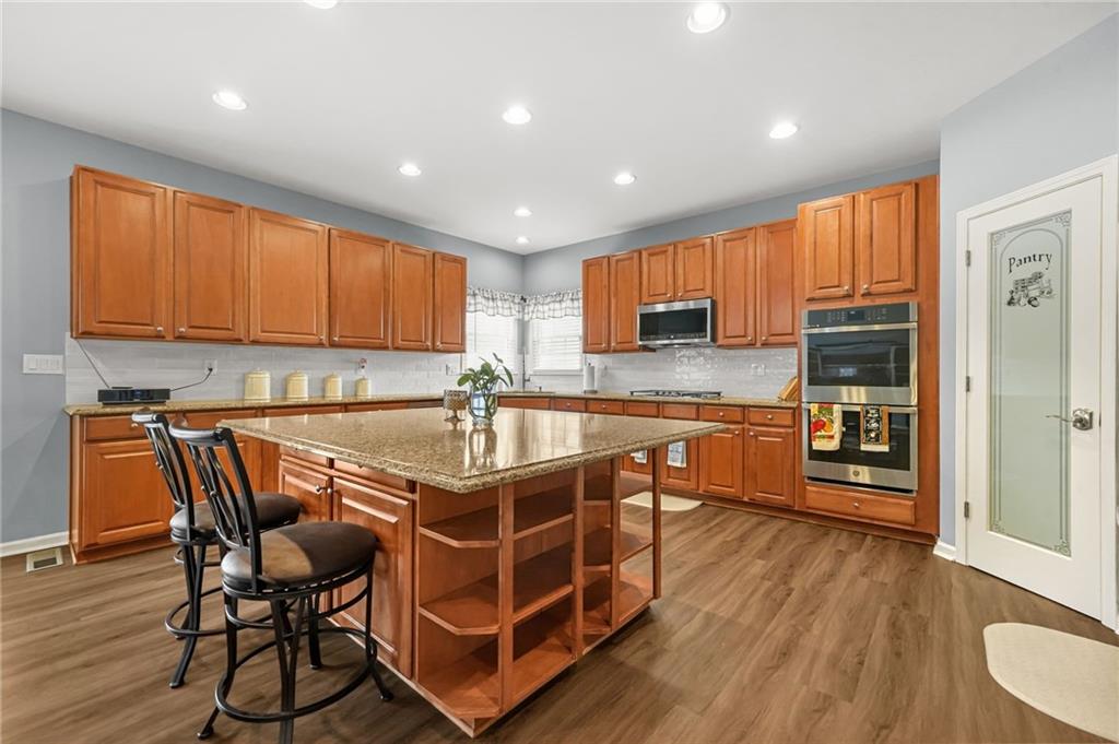 1203 Big Tree Pointe Villa Rica, GA 30180 - Photo 17 of 42 a kitchen with stainless steel appliances granite countertop a stove a sink dishwasher and a microwave with wooden floor