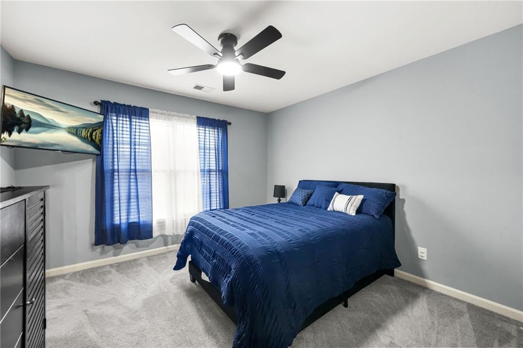 1203 Big Tree Pointe Villa Rica, GA 30180 - Photo 21 of 42 a bedroom with a large bed and a chandelier