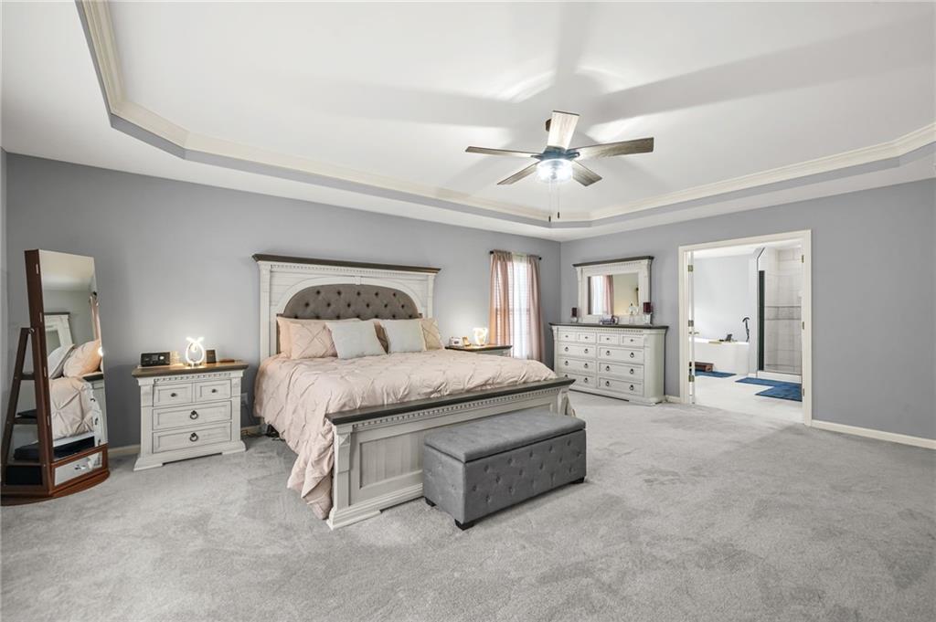 1203 Big Tree Pointe Villa Rica, GA 30180 - Photo 25 of 42 a spacious bedroom with a bed a chandelier and dresser