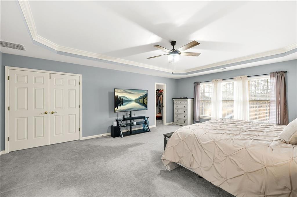 1203 Big Tree Pointe Villa Rica, GA 30180 - Photo 26 of 42 a spacious bedroom with a bed a table and a large window