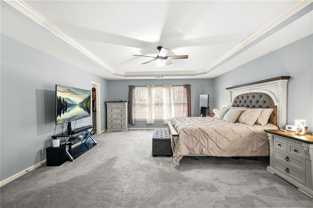 1203 Big Tree Pointe Villa Rica, GA 30180 - Photo 27 of 42 a bedroom with a bed a chandelier and a flat screen television