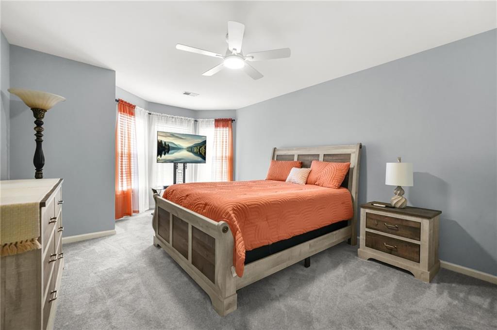 1203 Big Tree Pointe Villa Rica, GA 30180 - Photo 33 of 42 a spacious bedroom with a bed and a chandelier