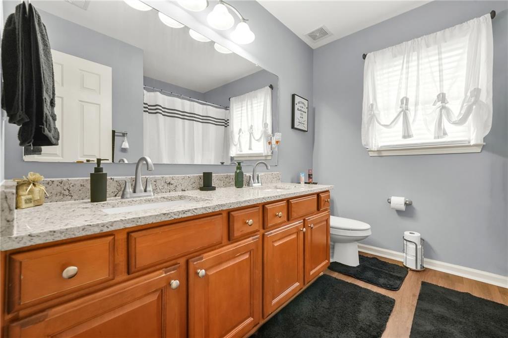 1203 Big Tree Pointe Villa Rica, GA 30180 - Photo 35 of 42 a bathroom with a granite countertop sink mirror vanity and toilet