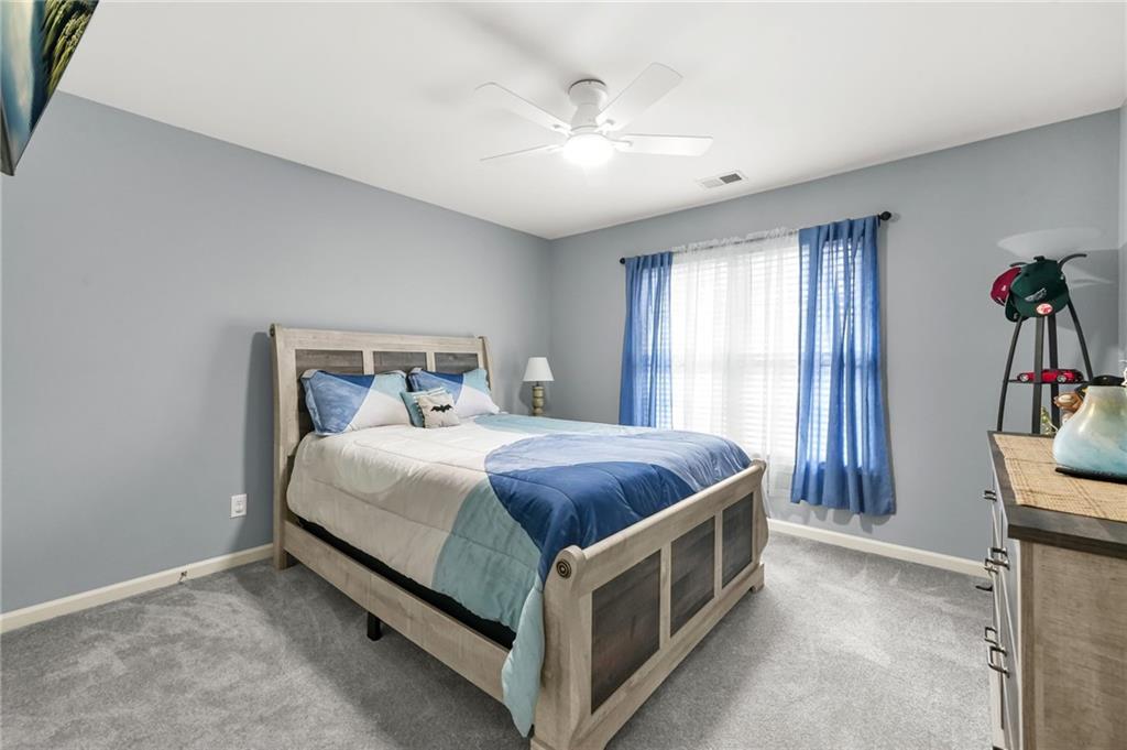 1203 Big Tree Pointe Villa Rica, GA 30180 - Photo 36 of 42 a spacious bedroom with a bed and a chandelier