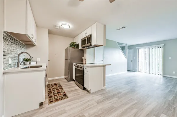 a kitchen with granite countertop a sink stove and refrigerator