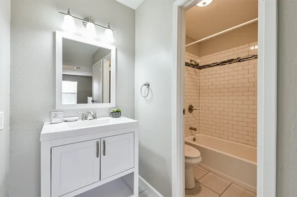 a bathroom with a double vanity sink toilet mirror and shower