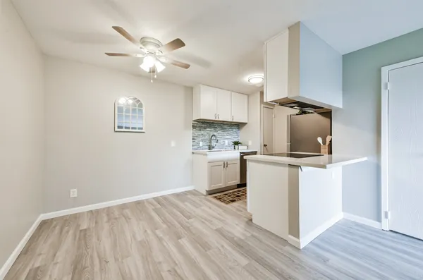 a kitchen with a refrigerator and white cabinets