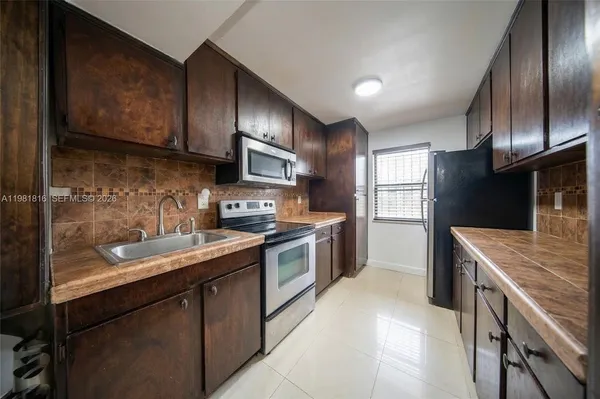 a kitchen with granite countertop stainless steel appliances and wooden cabinets