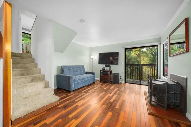 a living room with furniture a flat screen tv and floor to ceiling windows