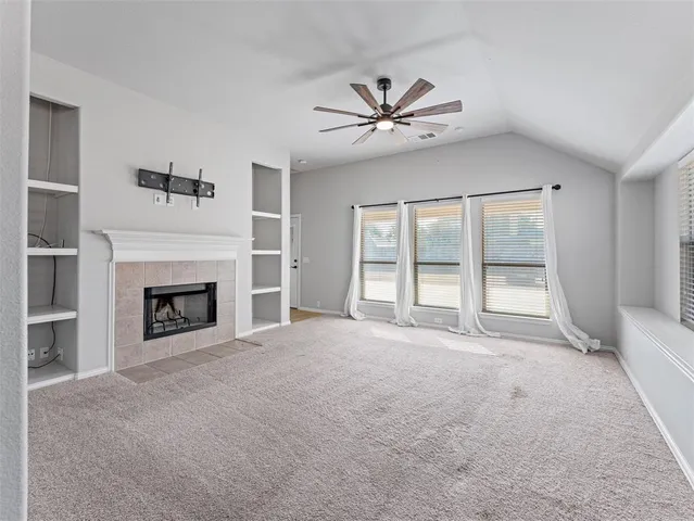a view of an empty room with a fireplace and a window