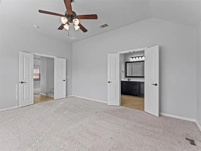 a view of a livingroom with a chandelier fan and kitchen space