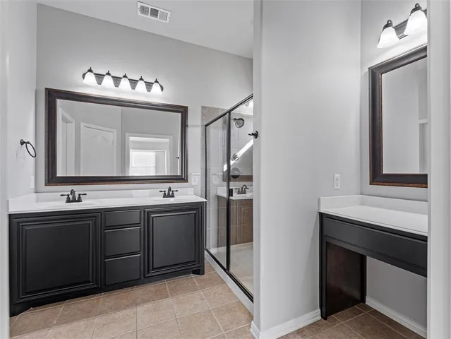 a bathroom with double vanity and a mirror