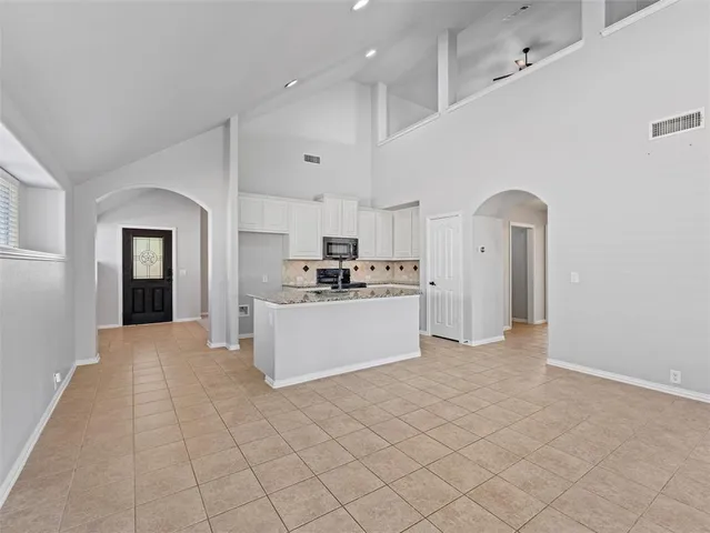 a large white kitchen with cabinets