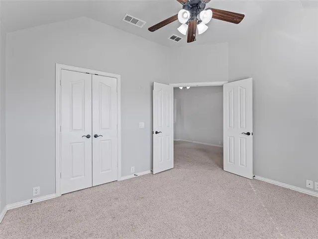 a view of an empty room and a ceiling fan