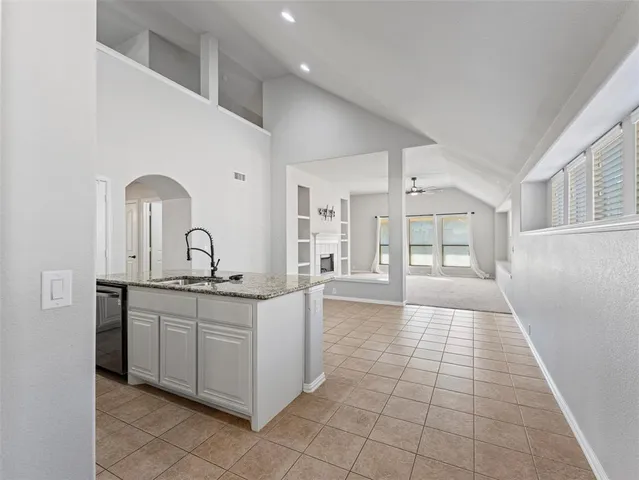 a large white kitchen with a sink and dishwasher a stove with wooden floor